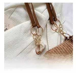 Detail of brown corduroy tote featuring gold metal chain links and fashion label