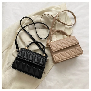 Detail of mini quilted crossbody bags with geometric triangle pattern and gold hardware