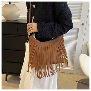 Close-up of brown fringe shoulder bag with long tassels and gold metal hardware detail