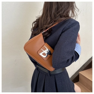 Vista dettagliata di una borsa baguette marrone con chiusura geometrica in metallo argento