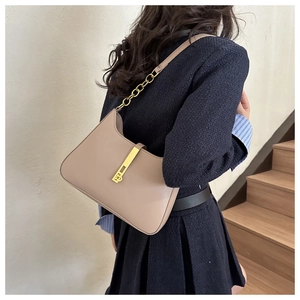 Chic apricot leather underarm bag featuring a gold chain strap and sleek metal buckle
