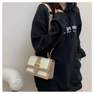 Détail du rabat tissé et du fermoir H doré sur le sac bandoulière beige bicolore