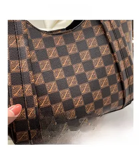 Close-up of deep brown pebbled leather texture with monogram checkerboard print