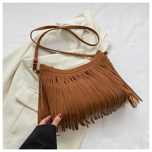 Close-up of brown suede tassel bucket bag with bohemian style and adjustable strap