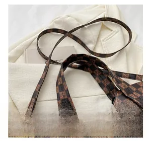 Detail of vintage tote bag with adjustable shoulder strap and monogram pattern