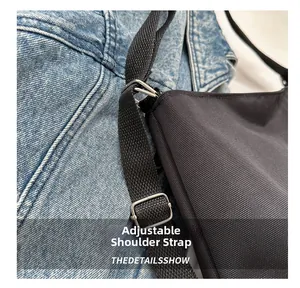 Detail of adjustable woven shoulder strap with silver metal buckle on a black tote bag