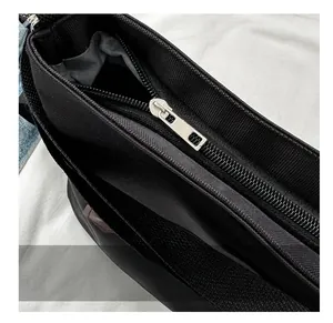 Close-up detail of smooth silver metal zipper and dark grey lining on black canvas bag