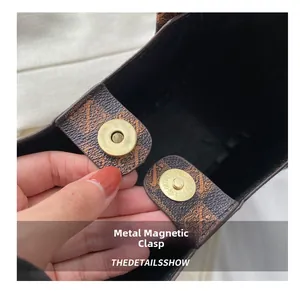 Detailed macro view of the vintage bronze magnetic buckle on a printed tote bag