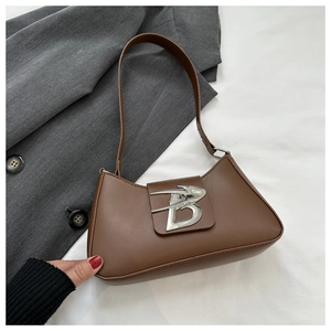 Dettaglio ravvicinato della borsa baguette in pelle marrone con fibbia a B in metallo argento