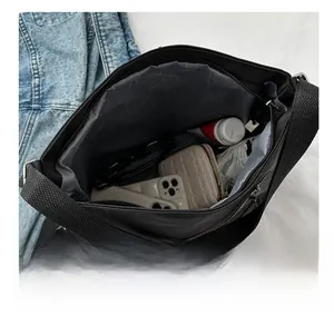 Interior view of black canvas tote bag showing grey lining with pockets and daily essentials