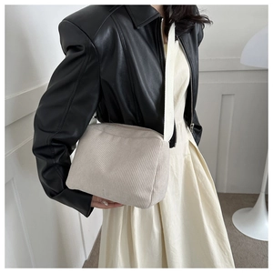 Detailed texture of beige corduroy shoulder bag with soft vertical stripes and wide strap