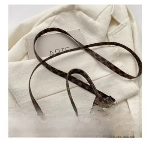 Detail of adjustable metal buckle and vintage brown leather strap on a small square bag