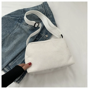 Close-up of white corduroy small square crossbody bag with adjustable wide strap