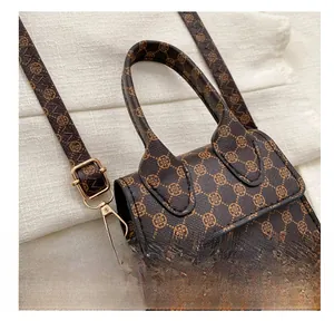 Detail of vintage monogram shoulder bag with gold metal hardware and brown leather handle