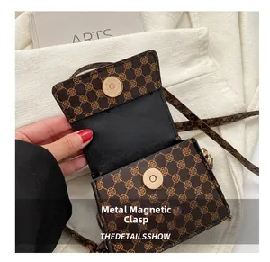 Detail of vintage brown mini crossbody bag with floral pattern and magnetic snap closure