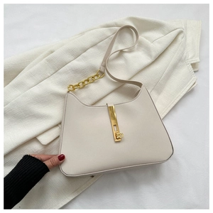 Detail of cream leather shoulder bag with gold chain strap and metallic lock on suit