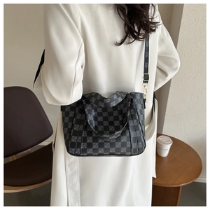 Detailed back view of a black checkerboard tote bag with adjustable strap for daily use