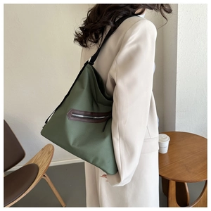 Army green large tote bag with brown leather trim zipper pocket and black strap