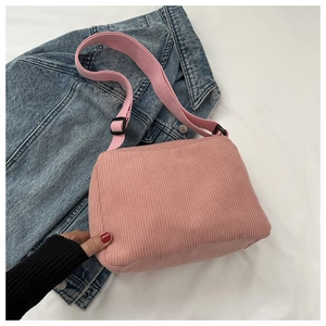 Detailed macro view of pink corduroy fabric texture on a stylish rectangular crossbody bag