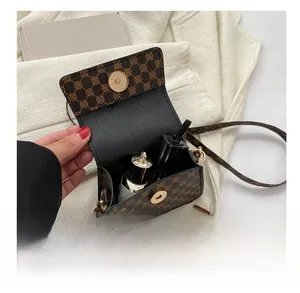 Detail view of mini crossbody bag showing interior storage for lipstick and cosmetics