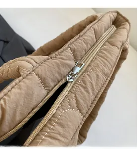 Detail of smooth khaki quilted tote bag zipper and fine stitching craftsmanship