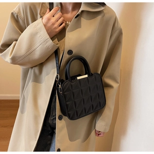 Dettaglio borsa nera in pelle PU con trama trapuntata 3D geometrica e inserti in metallo oro