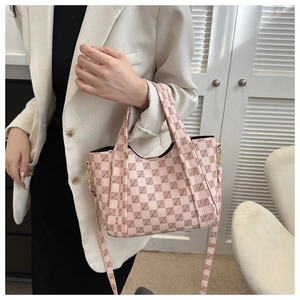 Detail of pink geometric pattern tote bag with gold metal hardware and detachable strap