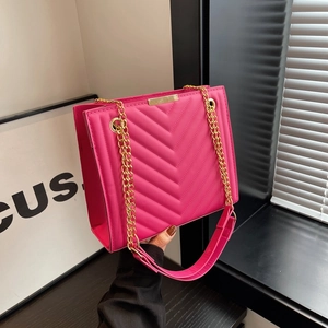 Chic magenta quilted crossbody bag with golden chain strap and V-shaped stitching detail