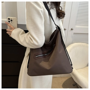 Detail of deep brown large capacity nylon shoulder bag with diagonal metal zipper pocket