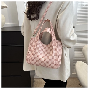 Pink retro monogram tote bag with adjustable strap worn by model in a modern room