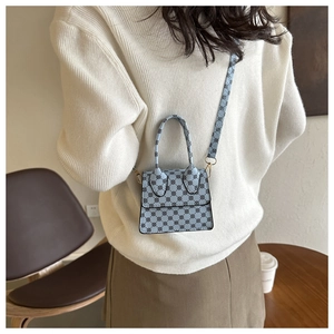 Mini light blue crossbody bag with polka dots shown with a casual knit outfit