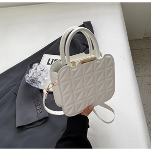 Dettaglio borsa trapuntata bianca con rifiniture dorate su sfondo di moda elegante