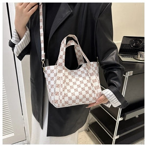 Detail view of a vintage checkered tote bag with brown letter print and detachable strap