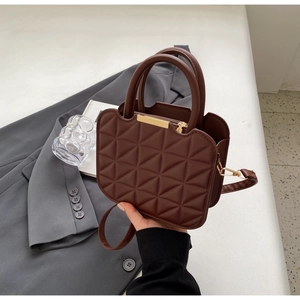 Dettaglio borsa trapuntata marrone caffè con zip dorata e tracolla rimovibile