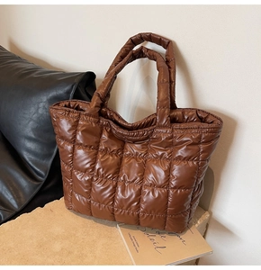 Close-up of brown quilted tote bag showing plush texture and caramel stitching details
