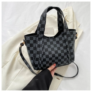 Close-up of checkerboard tote bag with elegant golden hardware and leather texture