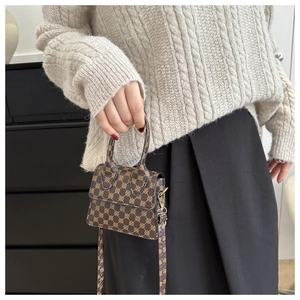 Miniature vintage monogram shoulder bag shown held by model for scale and style