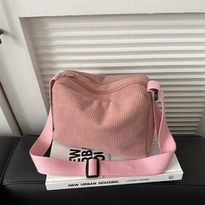Pink corduroy tote bag with adjustable strap placed on a book for a modern chic style