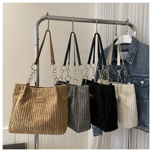 Detailed close-up of corduroy tote bags in khaki, grey, black and cream with chain straps