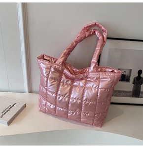 Detail of pink quilted tote bag with glossy metallic finish and spacious down-filled design