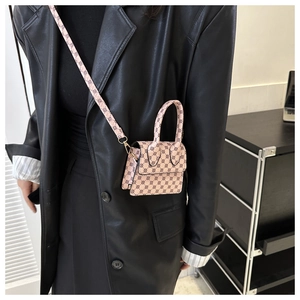 Detail of mini pink crossbody bag with black geometric pattern and metallic buckle