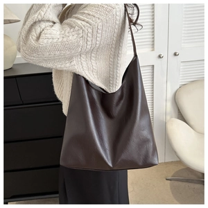 Detailed view of large dark coffee faux leather hobo tote bag on model for daily commute