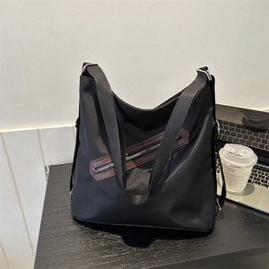 Large capacity black nylon tote bag with brown leather trim and adjustable shoulder strap