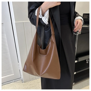 Detail shot of a large caramel soft leather tote bag showing texture and supple material