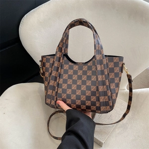 Retro plaid tote bag with brown checkered print and adjustable shoulder strap on a white chair