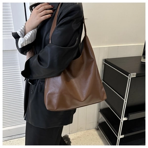 Brown large capacity hobo tote bag with matte leather finish shown on shoulder