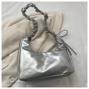 Detail of silver metallic hobo bag with pleated shoulder strap and side tassels