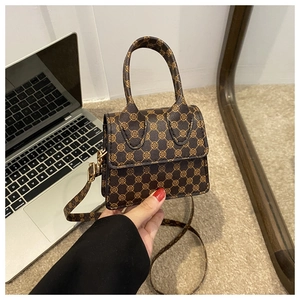 Detail of vintage brown monogram mini handbag with gold hardware and top handle strap