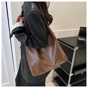 Close-up of a large brown leather tote bag showing soft texture and premium grain details