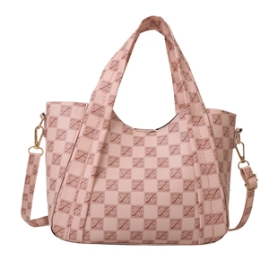 Pink vintage monogram tote bag with gold hardware and adjustable strap on white background